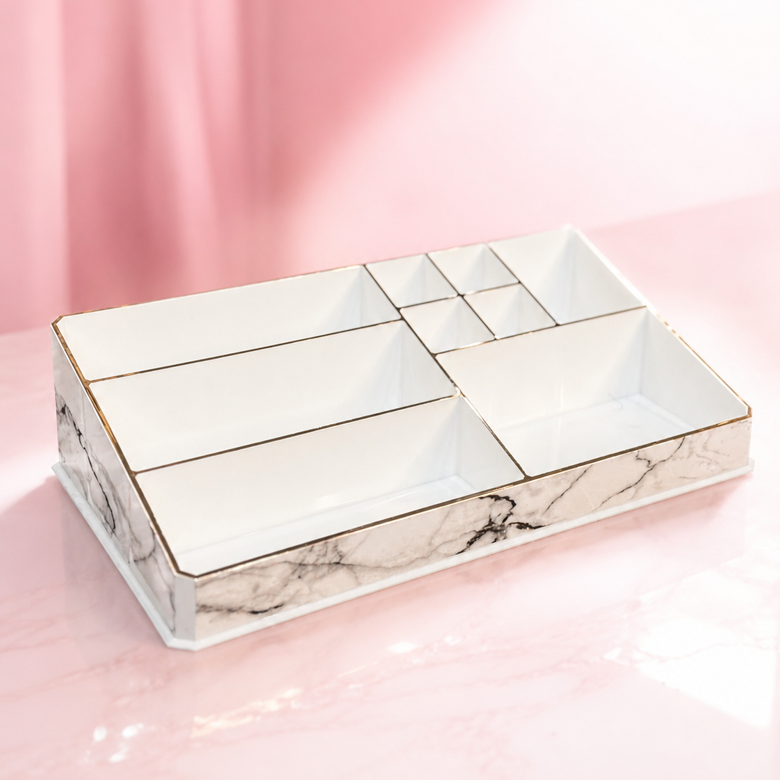 A white marble-patterned cosmetic organizer tray with gold trim and multiple compartments, shown on a pink background. The brand logo 'ECLAT BY TUBA' is visible in the top left corner.