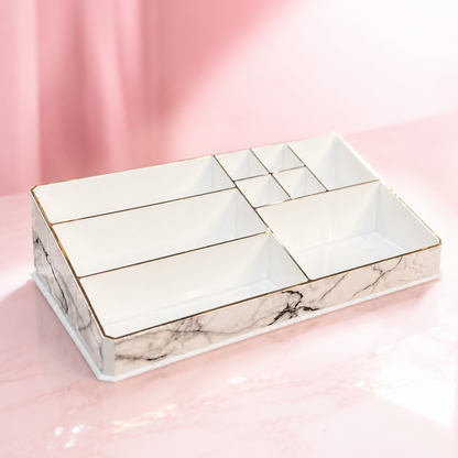 A white marble-patterned cosmetic organizer tray with gold trim and multiple compartments, shown on a pink background. The brand logo 'ECLAT BY TUBA' is visible in the top left corner.