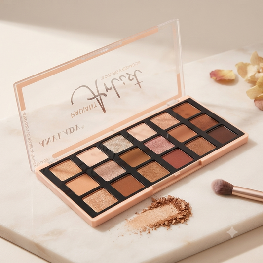 A 16-shade eyeshadow palette by Trish Lacey, shown open on a white marble surface with a makeup brush and loose powder nearby. The palette has a rose gold case and displays a variety of warm-toned shimmers, tans, and browns.