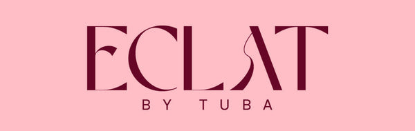 A square pink graphic with the text 'ECLAT BY TUBA' centered in dark burgundy lettering.